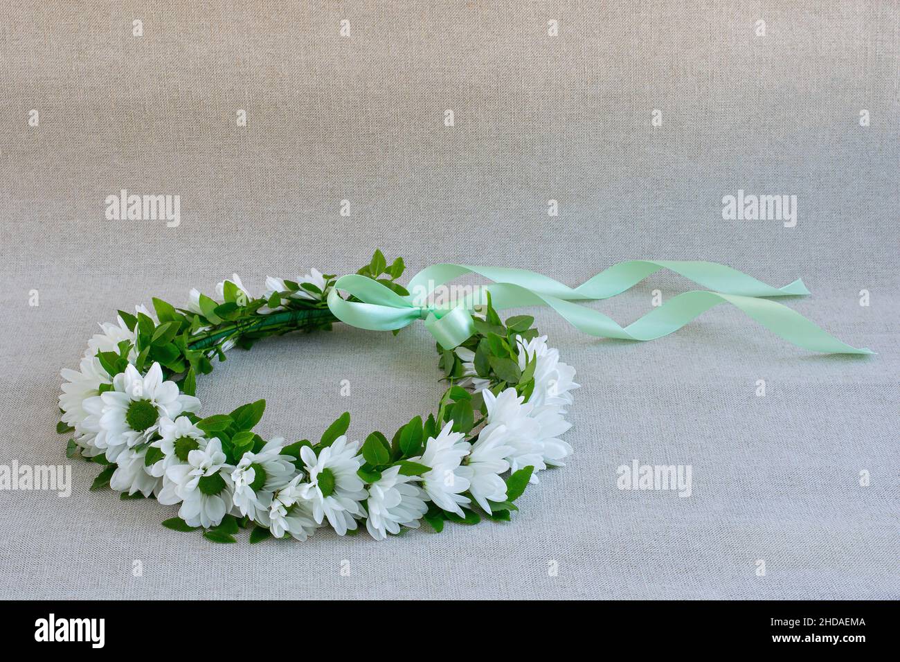 Wreath of white flowers on light linen background Stock Photo