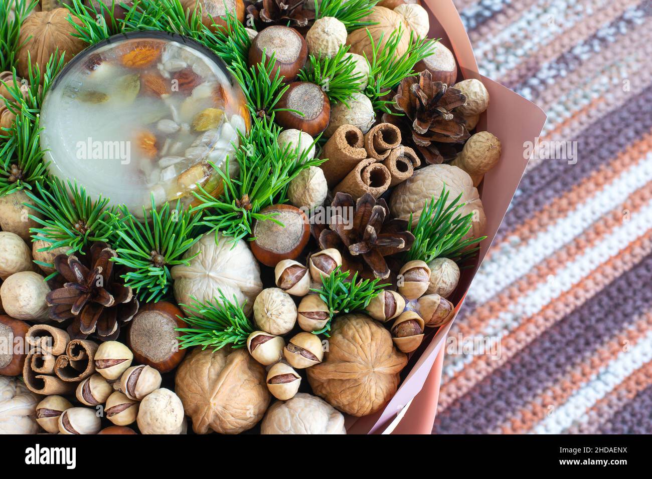 Nut composition with green pine branches on crochet background Stock Photo
