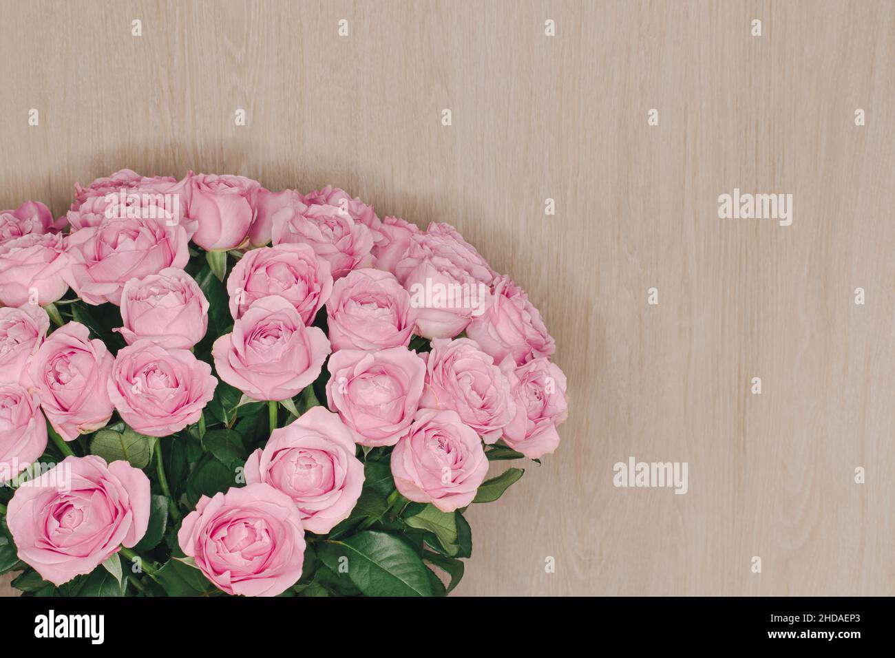 Large bouquet of delicate roses on light wooden background Stock Photo