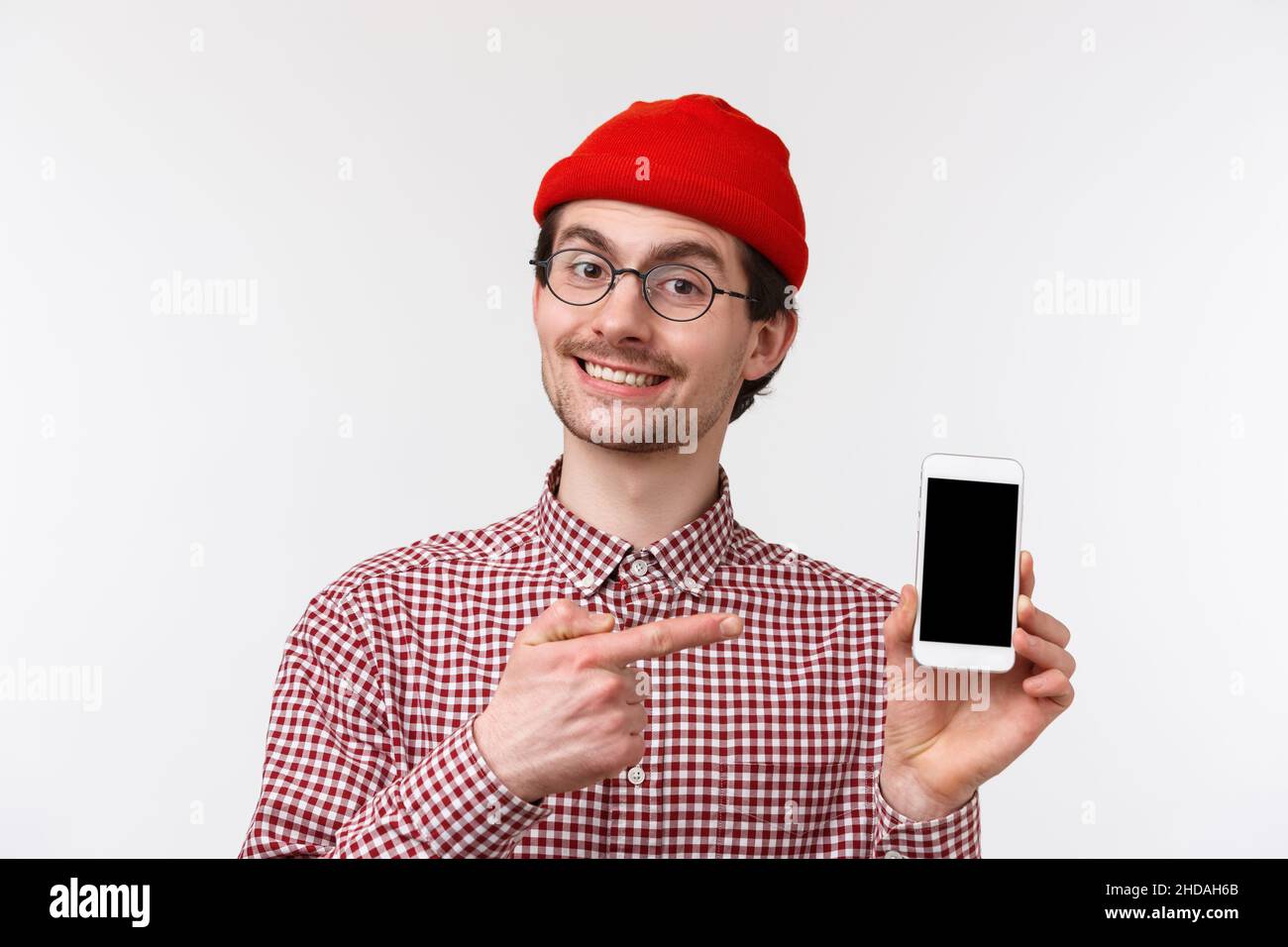 Technology and people concept. Close-up portrait young modern man with beard in beanie and glasses, showing his new application he programmed Stock Photo