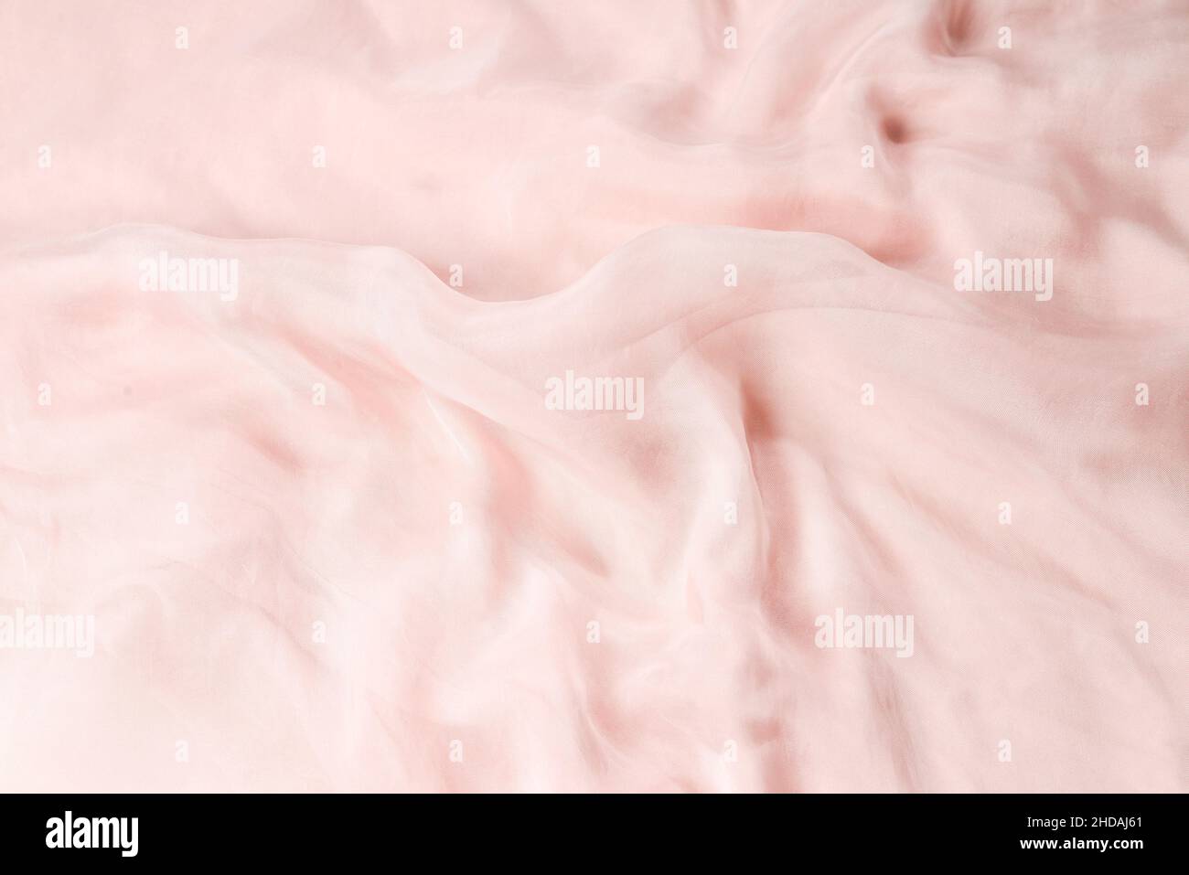 Soft smooth pink silk fabric background. Fabric texture. Stock Photo