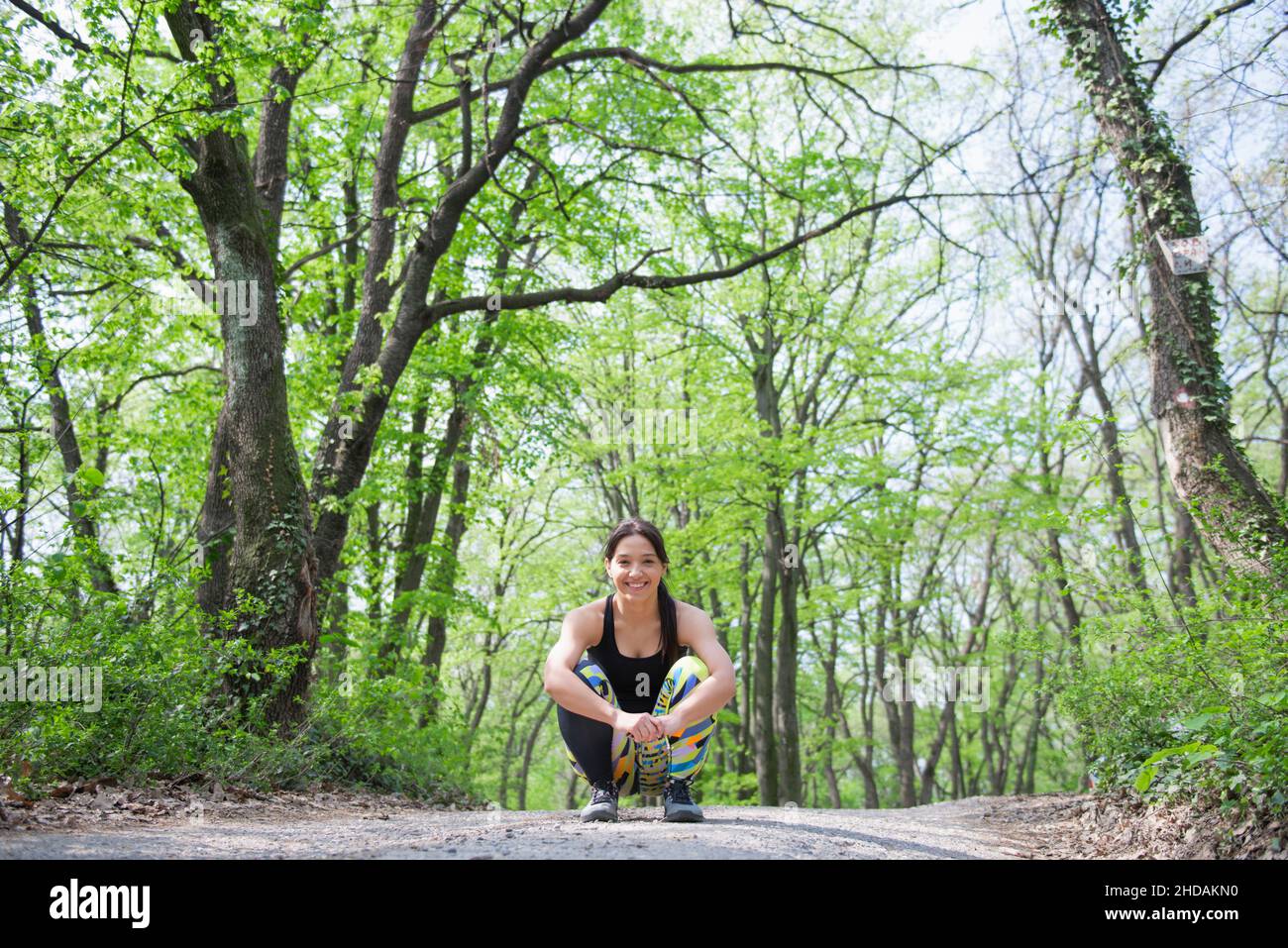 Relaxed and cheerful female athlete enjoying her training during the spring morning in the woods Stock Photo