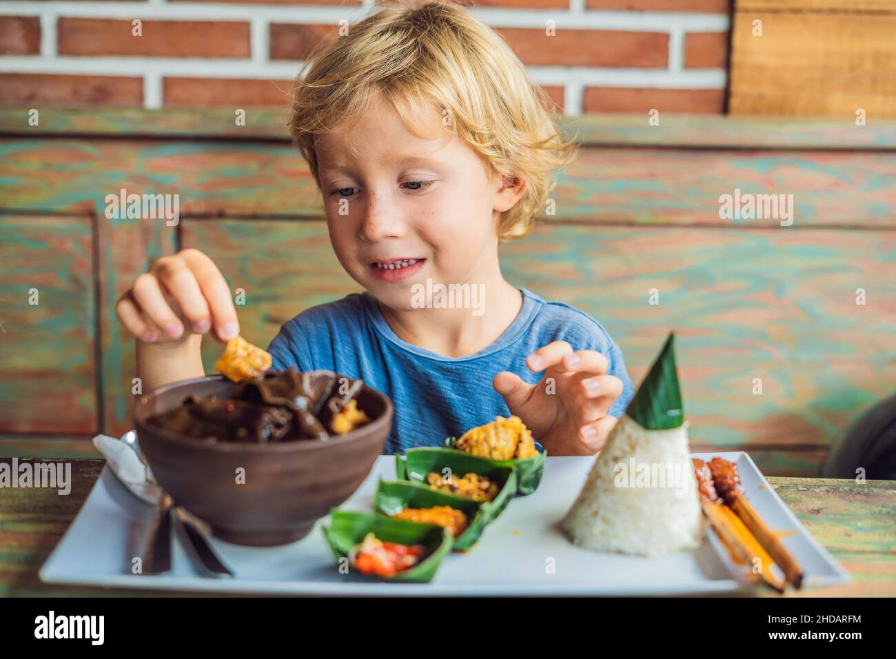 Boy eats in a cafe. Lifestyle. A dish consisting of rice, fried fish