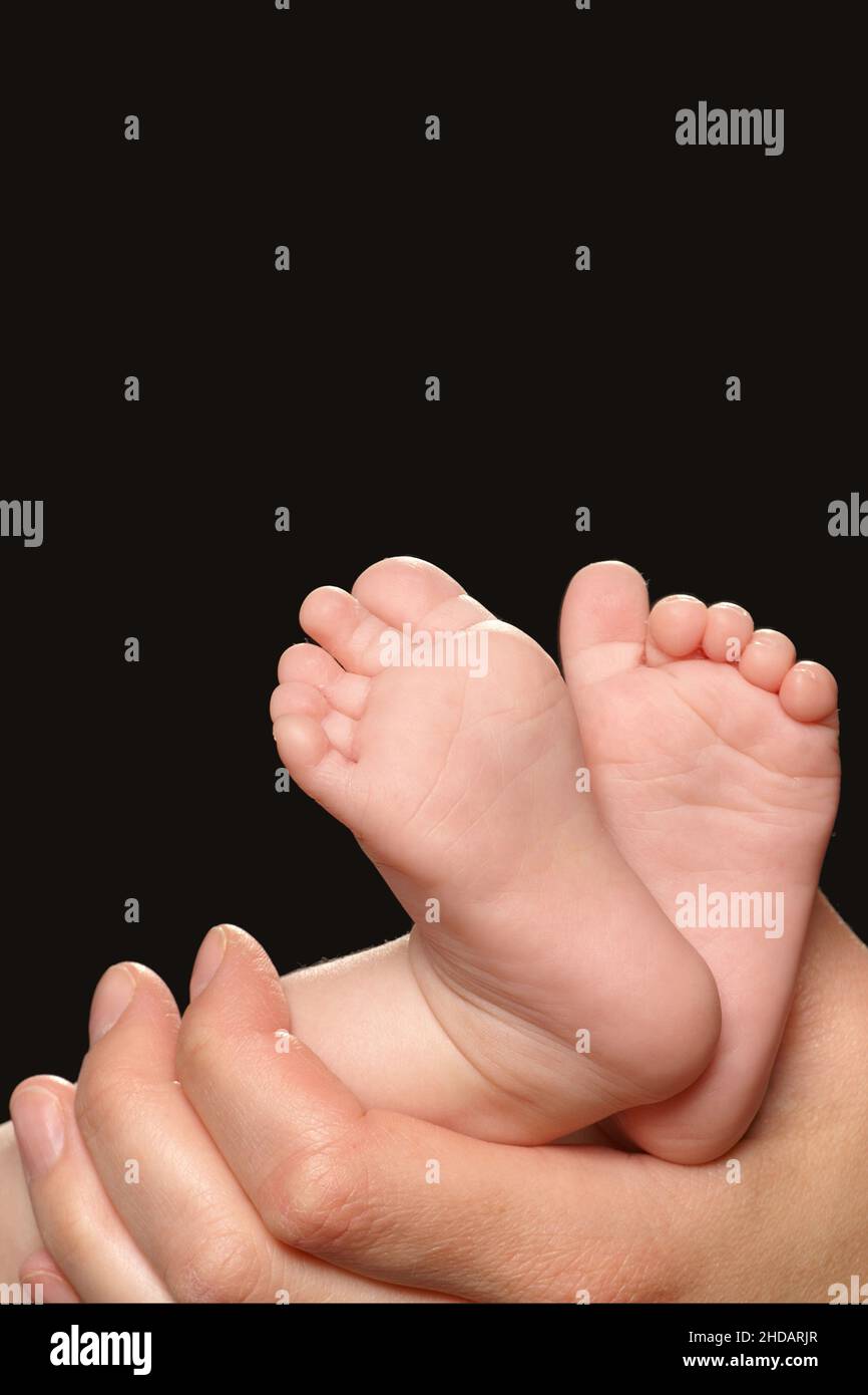 Hand hält die Füße eines Babys Stock Photo