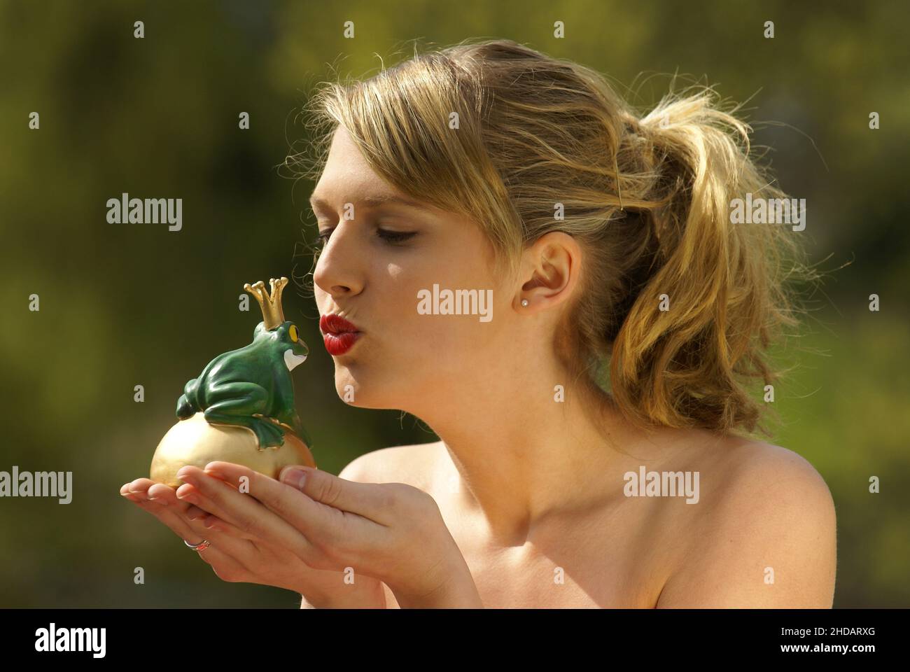 Junge Frau küsst einen Frosch mit Krone,  Froschkönig, Stock Photo