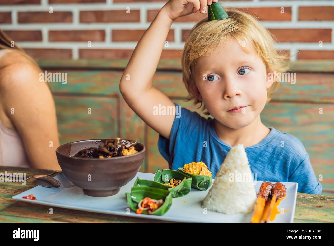 Boy eats in a cafe. Lifestyle. A dish consisting of rice, fried fish