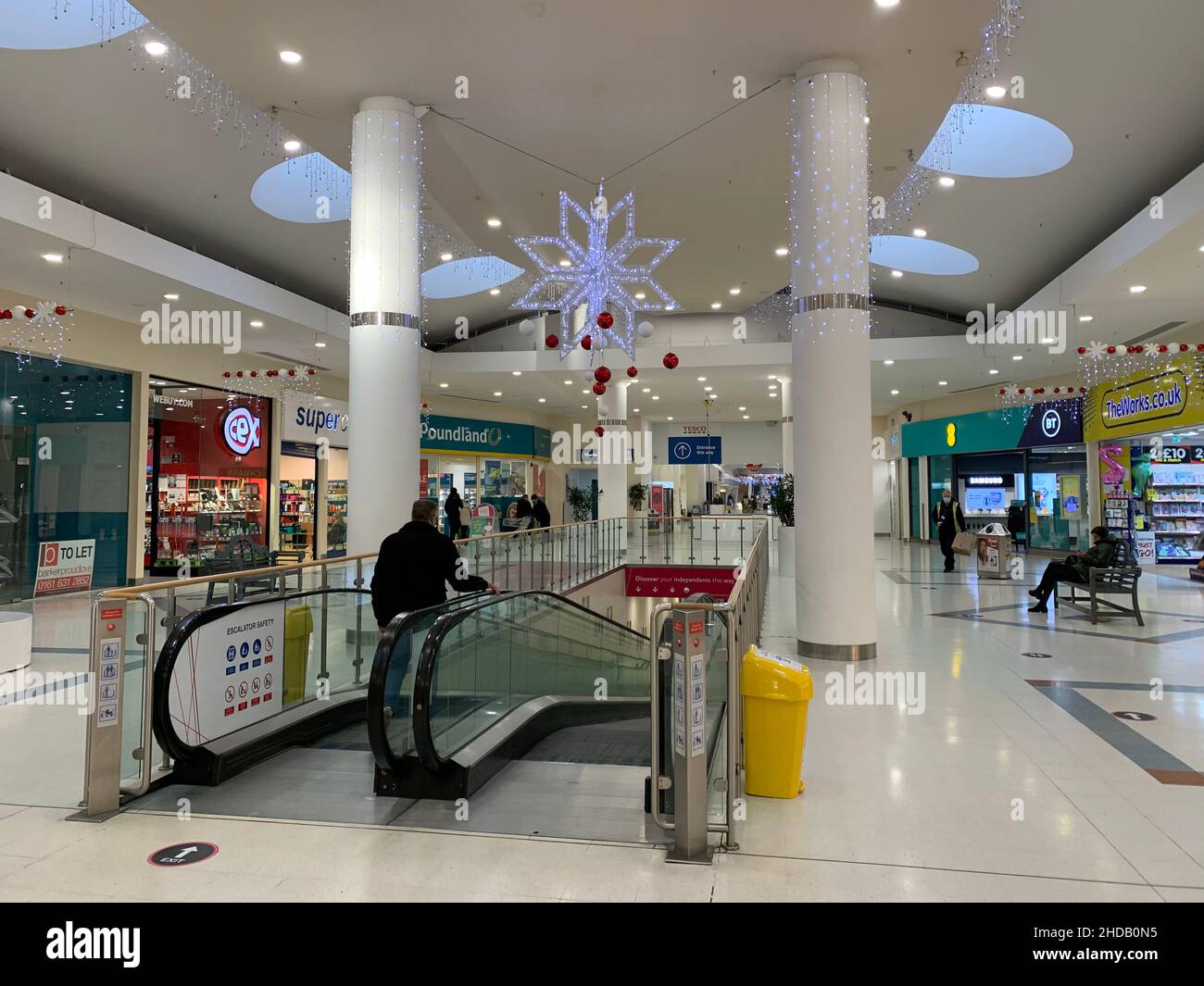 Weston Favell centre  Northampton shopping Centre UK pillars escalator stairs shop lights inside shinny floor lighting people buy sit seat seats star Stock Photo