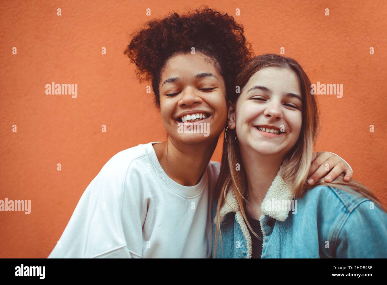 Portrait of two happy joyful teen girls of different races smiling at camera, enjoying friendship, multi-ethnic best female friends making selfie phot Stock Photo