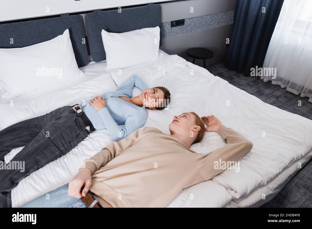 High angle view of smiling couple lying on bed in hotel room Stock ...