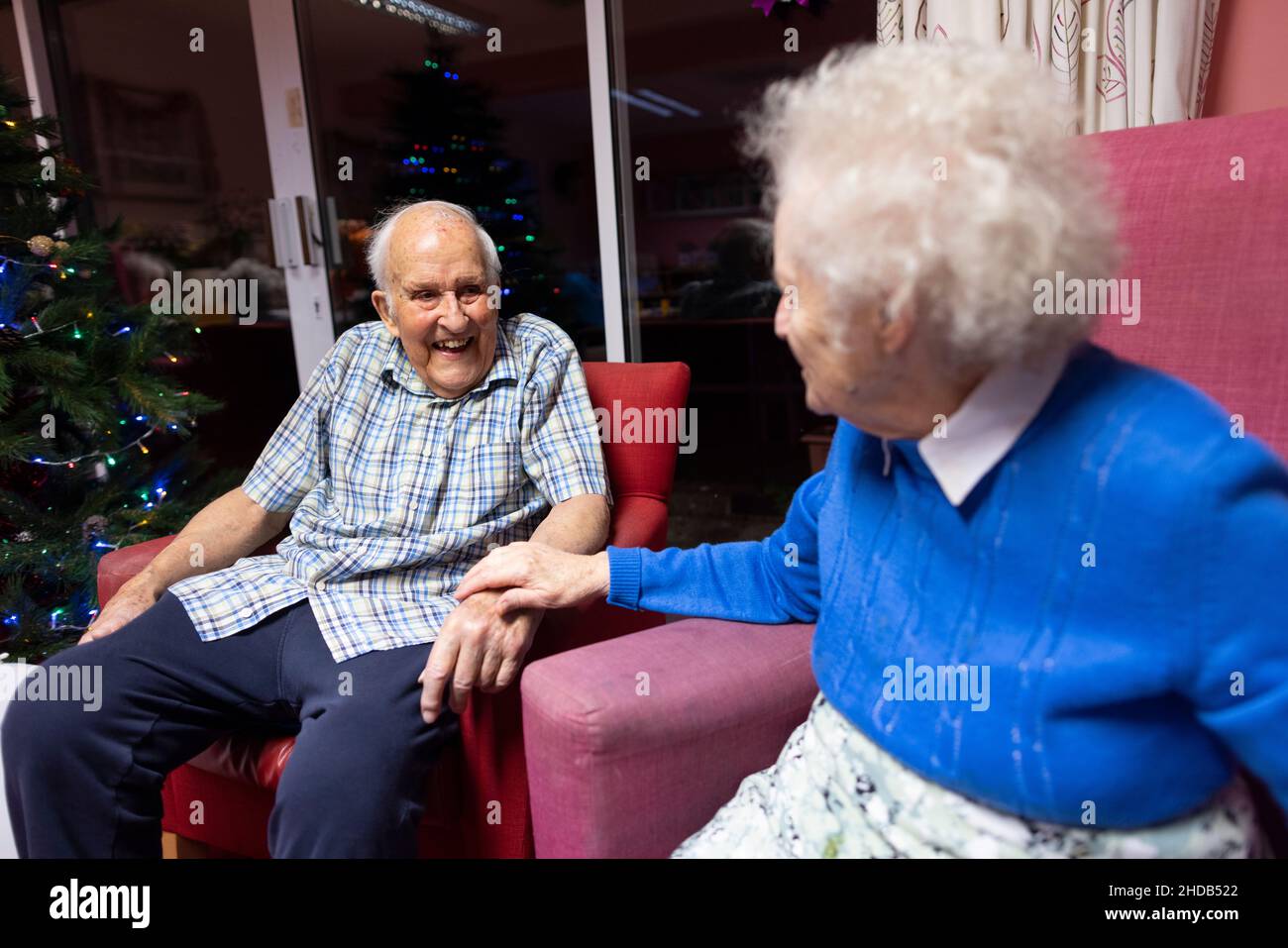 Elderly couple in their eighties sitting together at their residential care home, England, United Kingdom Stock Photo