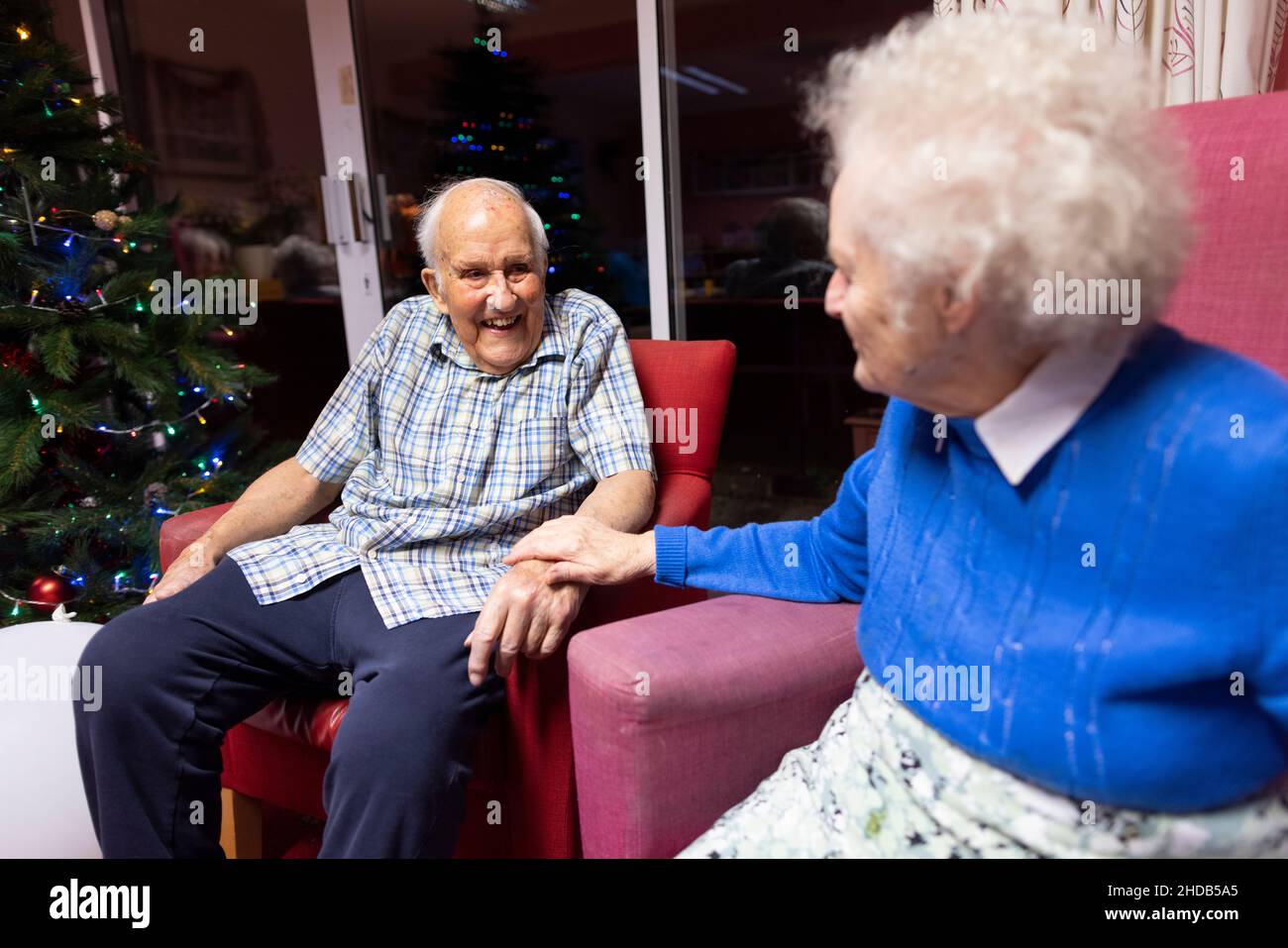 Elderly couple in their eighties sitting together at their residential care home, England, United Kingdom Stock Photo