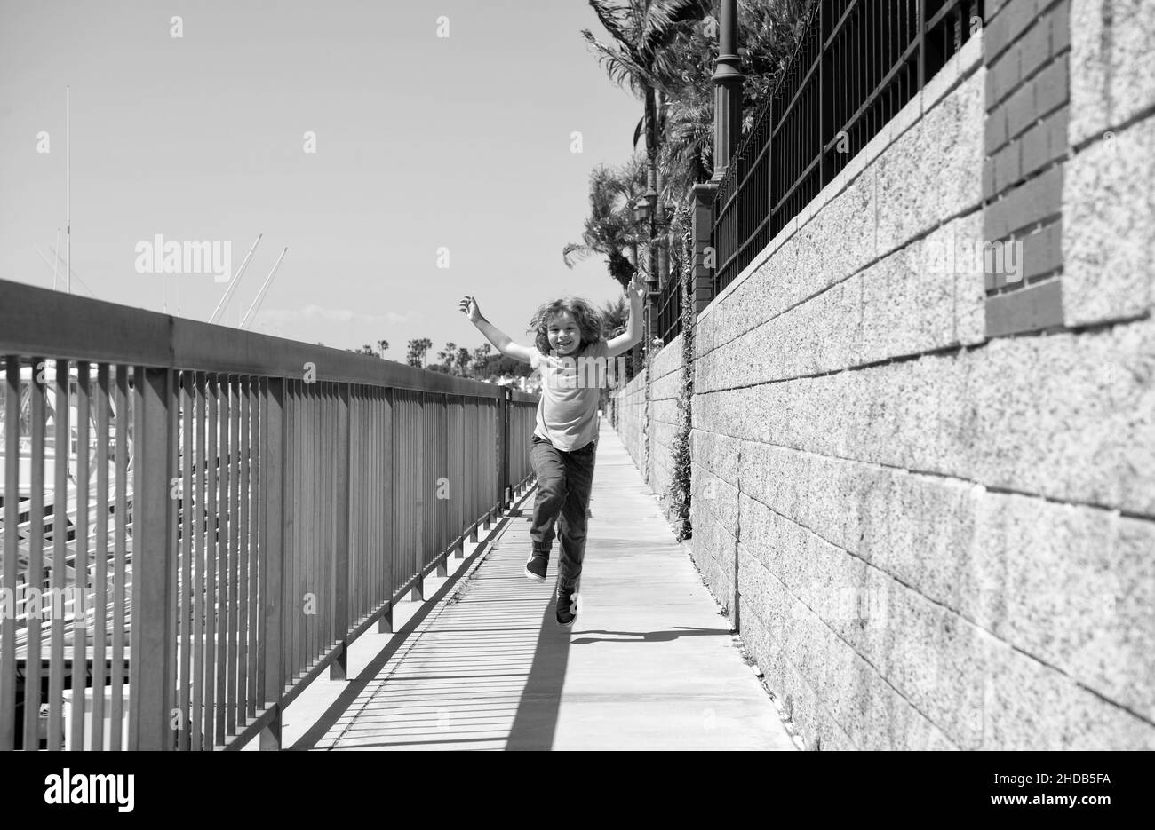 Happy boy kid enjoy summer vacation running on promenade, happiness Stock Photo