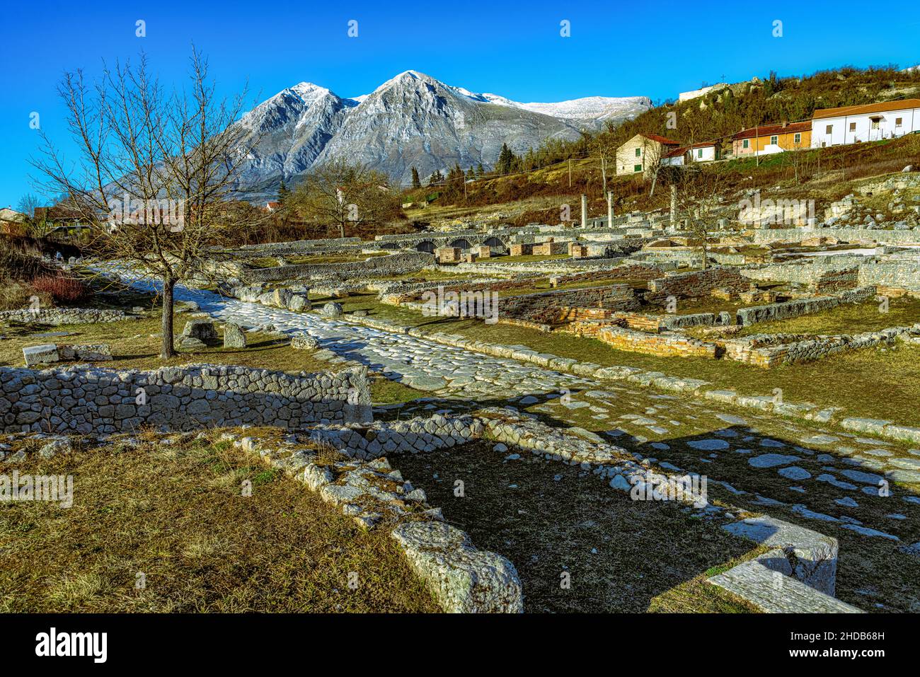 Ancient ruins of the Roman archaeological site of Alba Fucens. In the background the peaks of Velino. Massa d'Albe, Abruzzo Stock Photo