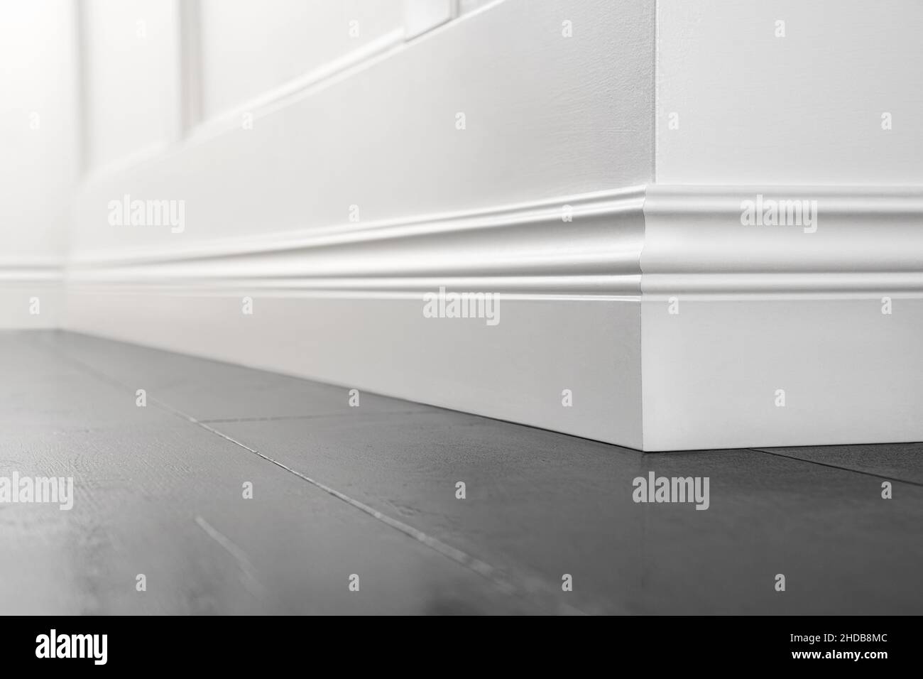 Close up of decorative, moulding white baseboard corner in empty room with copy space Stock Photo