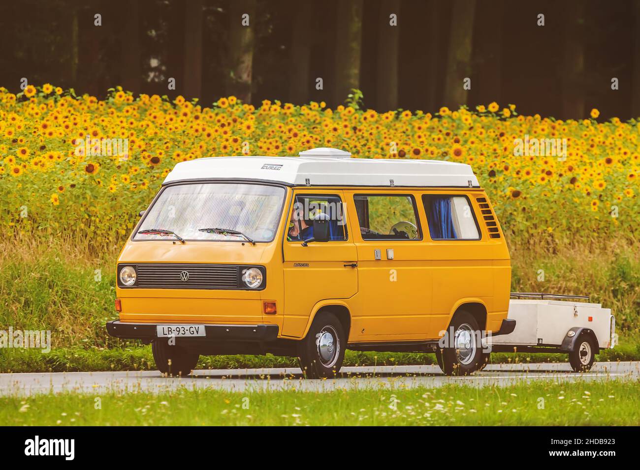 DIEREN, THE NETHERLANDS - AUGUST 14, 2016: Retro styled image of a Vintage Volkswagen Transporter with popup camper on a local road Stock Photo