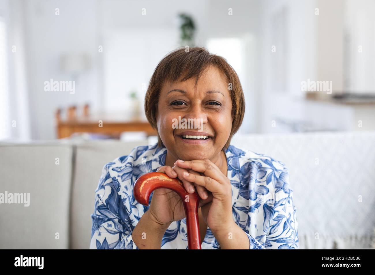 Portrait of happy african american senior woman with walking cane in living room at home Stock Photo