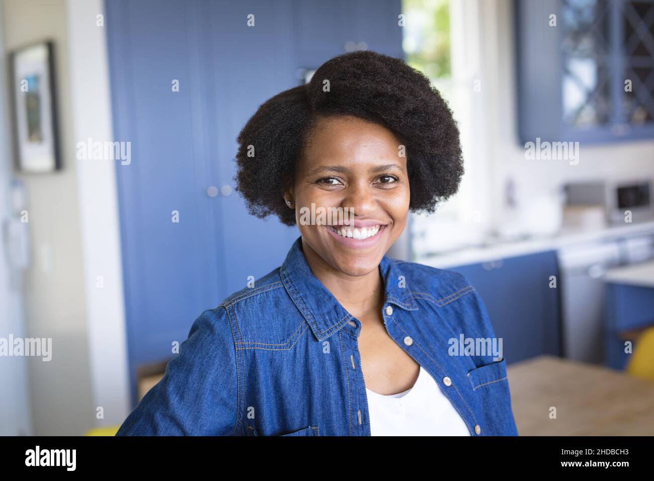 Portrait of happy african american woman in denim jacket at home Stock Photo