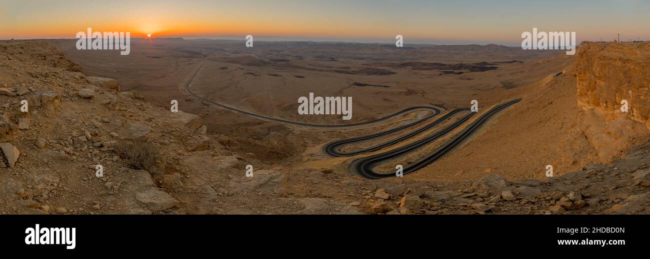 Panoramic sunrise view of a winding road and the landscape of Makhtesh (crater) Ramon, in the Negev Desert, Southern Israel. It is a geological landfo Stock Photo