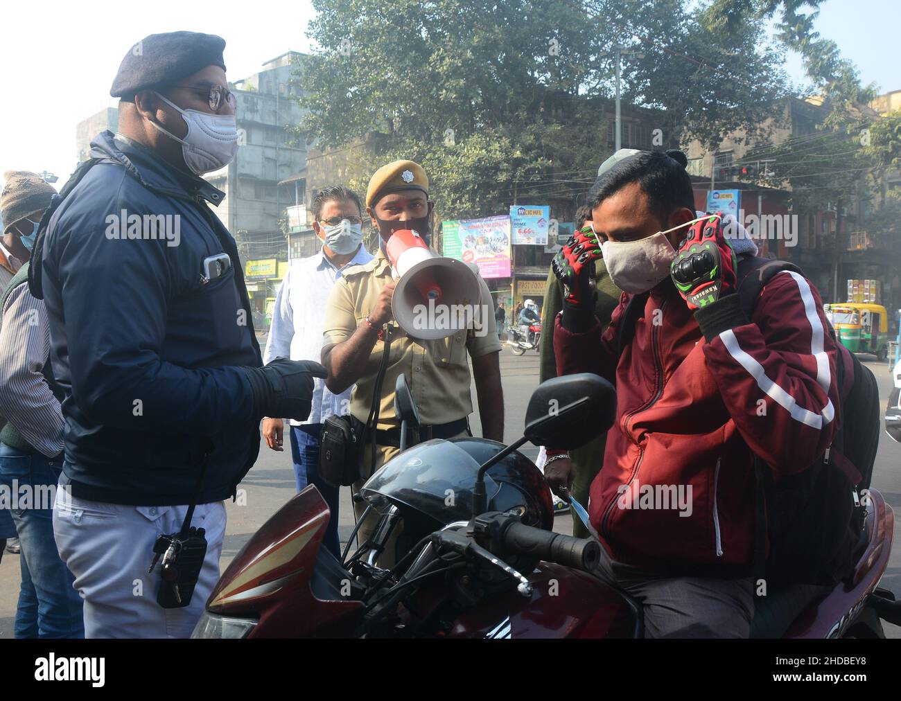 Kolkata, West Bengal, India. 5th Jan, 2022. Police take action on people who do not obey covid-19 protocols. Most of the people don't wear masks. It causes an increasing number of Covid and Omicron cases. That's why police are aware of local people, passengers, bus conductors, auto drivers and distribute masks. India's fresh Covid-19 cases have crossed the 50,000-in-a-day mark with several states like Maharashtra, Delhi, West Bengal, Karnataka and Tamil Nadu reporting a surge in their fresh infections. (Credit Image: © Rahul Sadhukhan/Pacific Press via ZUMA Press Wire) Stock Photo