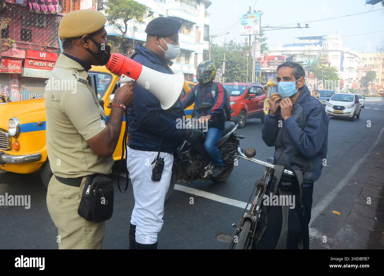 Kolkata, West Bengal, India. 5th Jan, 2022. Police take action on people who do not obey covid-19 protocols. Most of the people don't wear masks. It causes an increasing number of Covid and Omicron cases. That's why police are aware of local people, passengers, bus conductors, auto drivers and distribute masks. India's fresh Covid-19 cases have crossed the 50,000-in-a-day mark with several states like Maharashtra, Delhi, West Bengal, Karnataka and Tamil Nadu reporting a surge in their fresh infections. (Credit Image: © Rahul Sadhukhan/Pacific Press via ZUMA Press Wire) Stock Photo