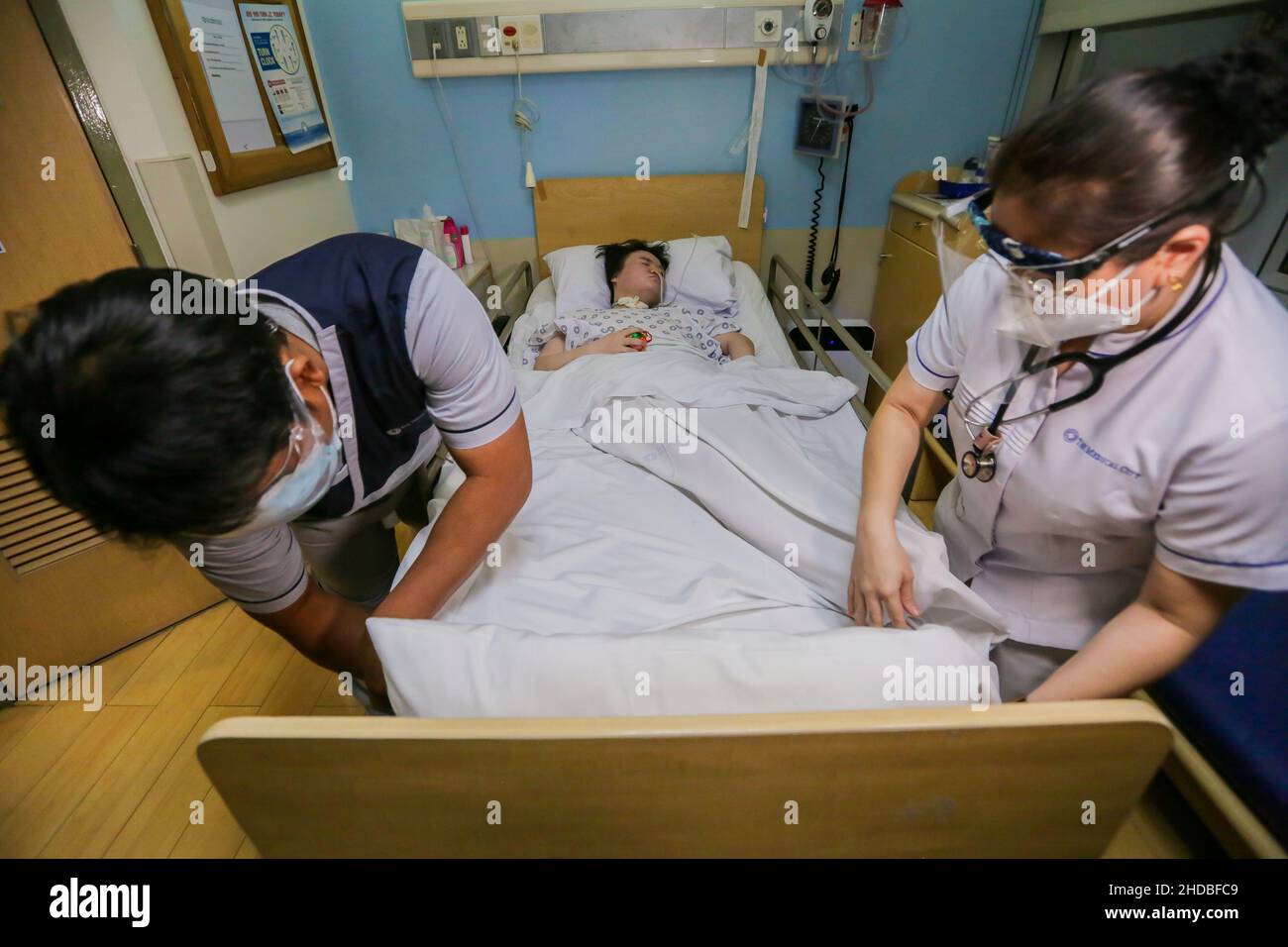 (220105) -- PASIG CITY, Jan. 5, 2022 (Xinhua) -- Nursing workers take care of Li Jinxin, a 26-year-old Chinese woman, at the Medical City hospital in Pasig City, the Philippines, Dec. 13, 2021. Li Jinxin has found her dream of returning home come true after battling a devastating illness for almost two and a half years in the Philippines that nearly cost her life.   Li spent 904 days bedridden in Medical City due to a brain hemorrhage.    TO GO WITH 'Feature: With help of Filipino medics, once critically-ill Chinese woman gets back home' (Xinhua/Rouelle Umali) Stock Photo