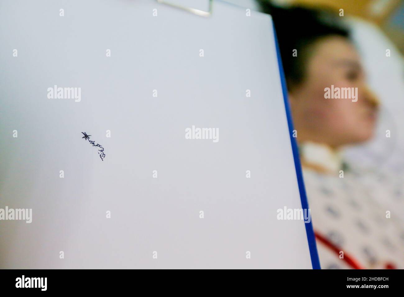 (220105) -- PASIG CITY, Jan. 5, 2022 (Xinhua) -- A nurse shows the handwriting of Li Jinxin, a 26-year-old Chinese woman, at the Medical City hospital in Pasig City, the Philippines on Dec. 13, 2021. Li Jinxin has found her dream of returning home come true after battling a devastating illness for almost two and a half years in the Philippines that nearly cost her life.   Li spent 904 days bedridden in Medical City due to a brain hemorrhage.    TO GO WITH 'Feature: With help of Filipino medics, once critically-ill Chinese woman gets back home' (Xinhua/Rouelle Umali) Stock Photo