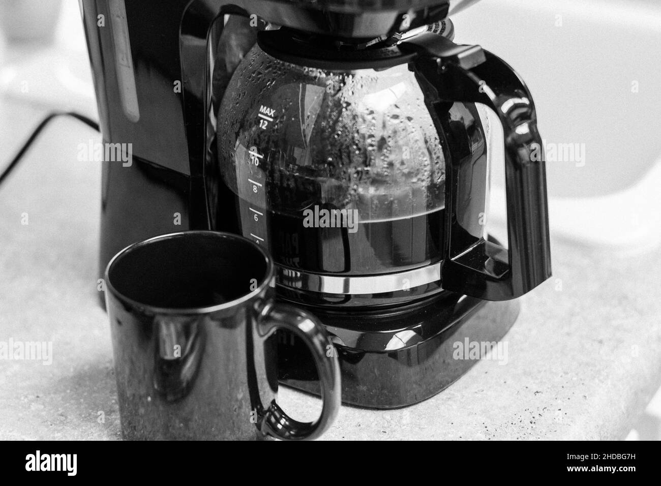 Grayscale top view of a coffee maker and a mug Stock Photo