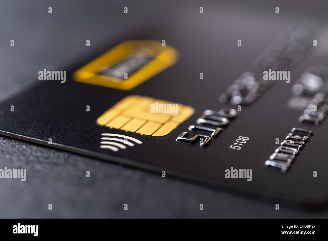 Credit card with chip and contactless technology macro. Black debit card for cash withdrawals and money transfers. Payment for goods and services. Stock Photo