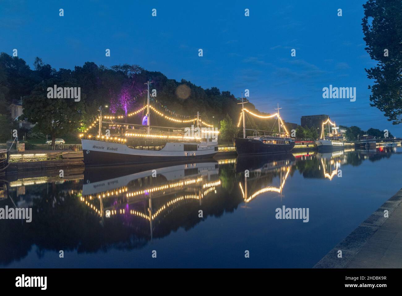 Turku, Finland - August 5, 2021: Beautiful night view on Aurajoki river with illuminated ships. Stock Photo