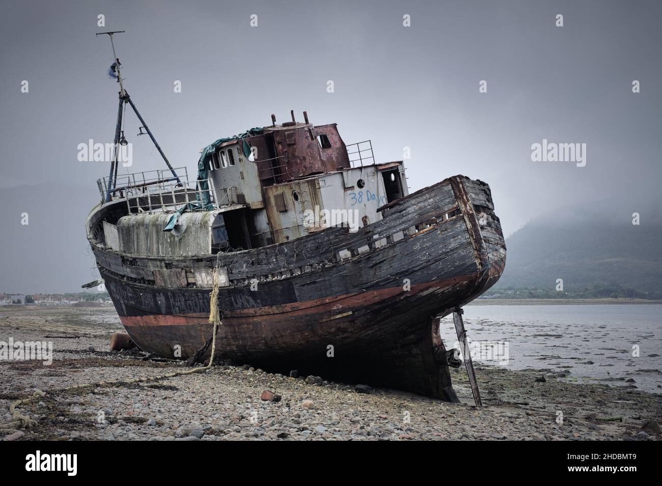 An appropriate place for a shipwreck, well, grounded and mostly abandoned former fishing trawler boat: Corpach takes its name from the Gaelic ('bodily Stock Photo
