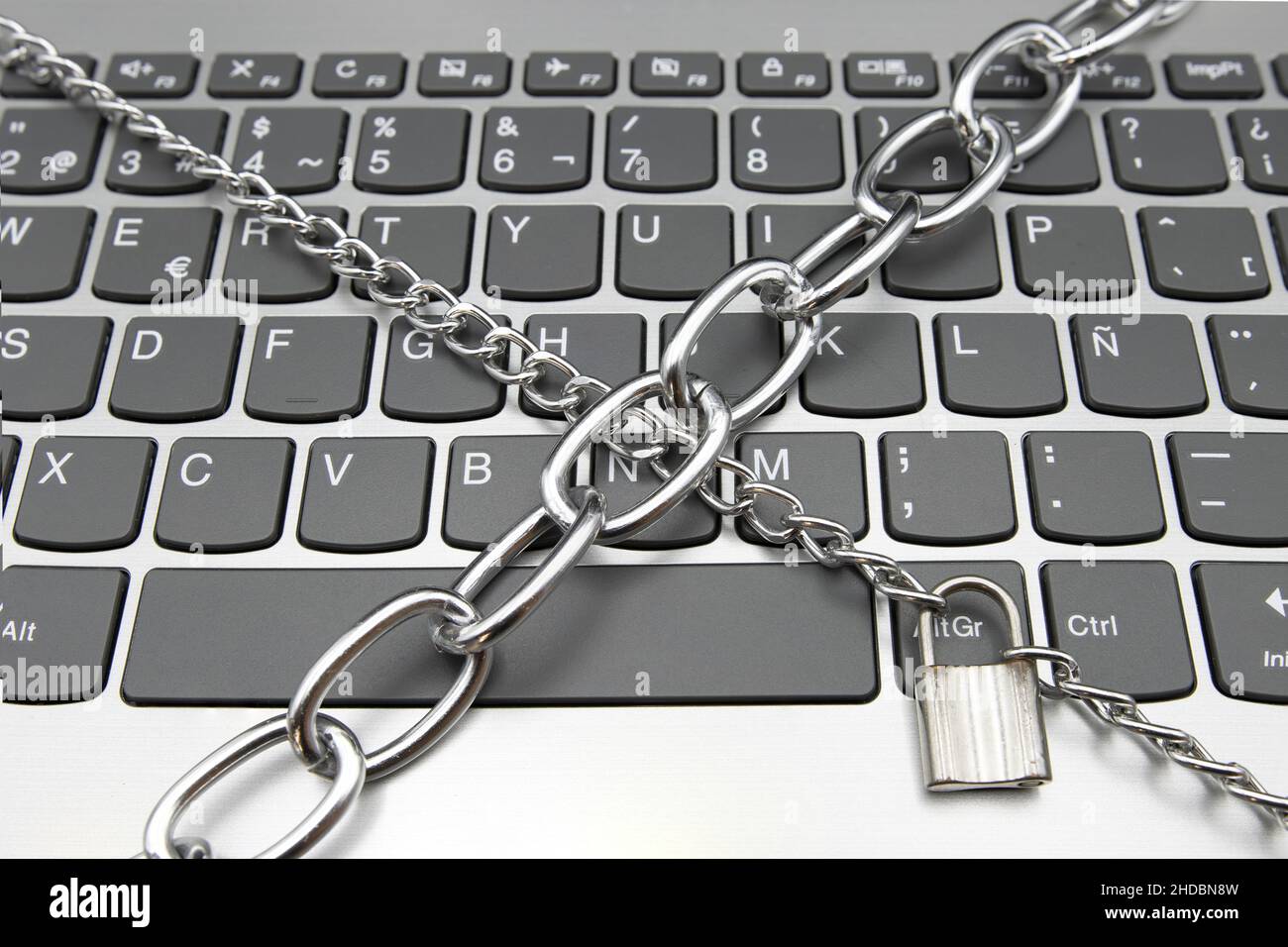A computer keyboard with a chain and a padlock, cybersecurity concept Stock Photo