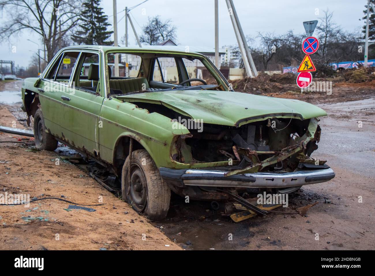 old wrecked green car on the street; Stock Photo