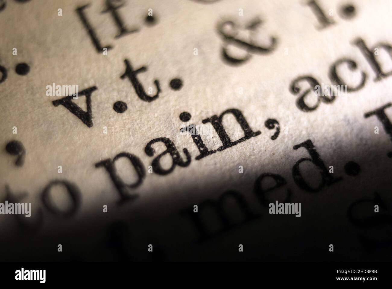 Word 'pain' printed on book page, macro close-up Stock Photo