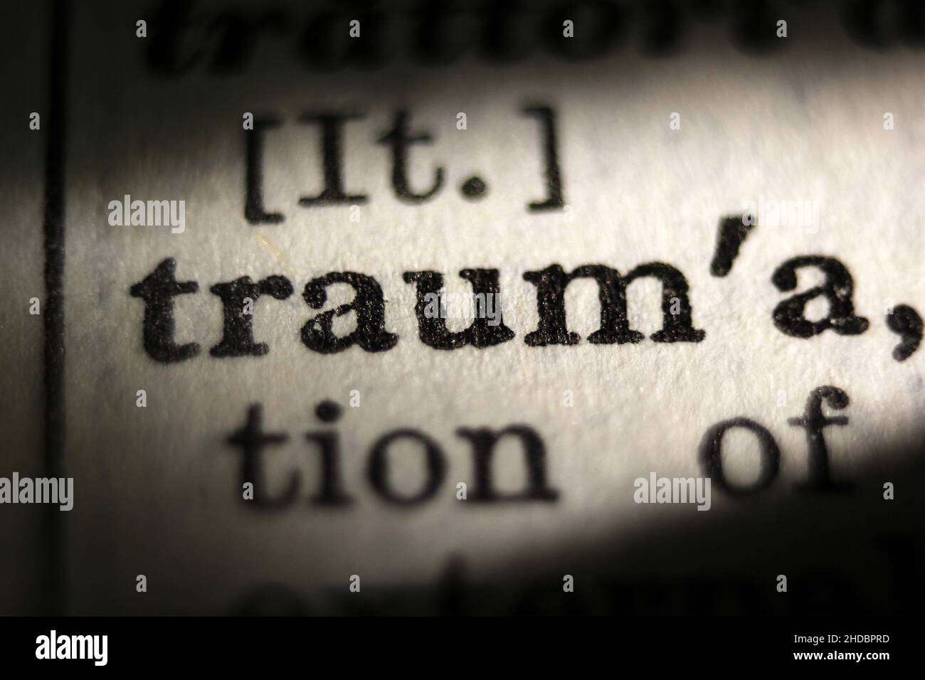 Word 'trauma' printed on book page, macro close-up Stock Photo
