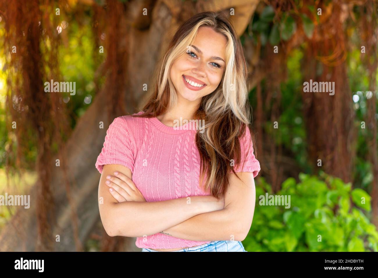 Young pretty blonde girl at outdoors keeping the arms crossed in ...