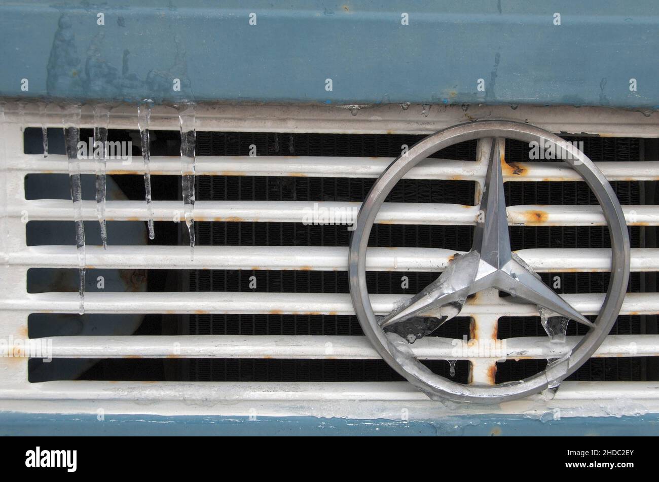 Mercedes star on radiator grille of truck with icicles Stock Photo