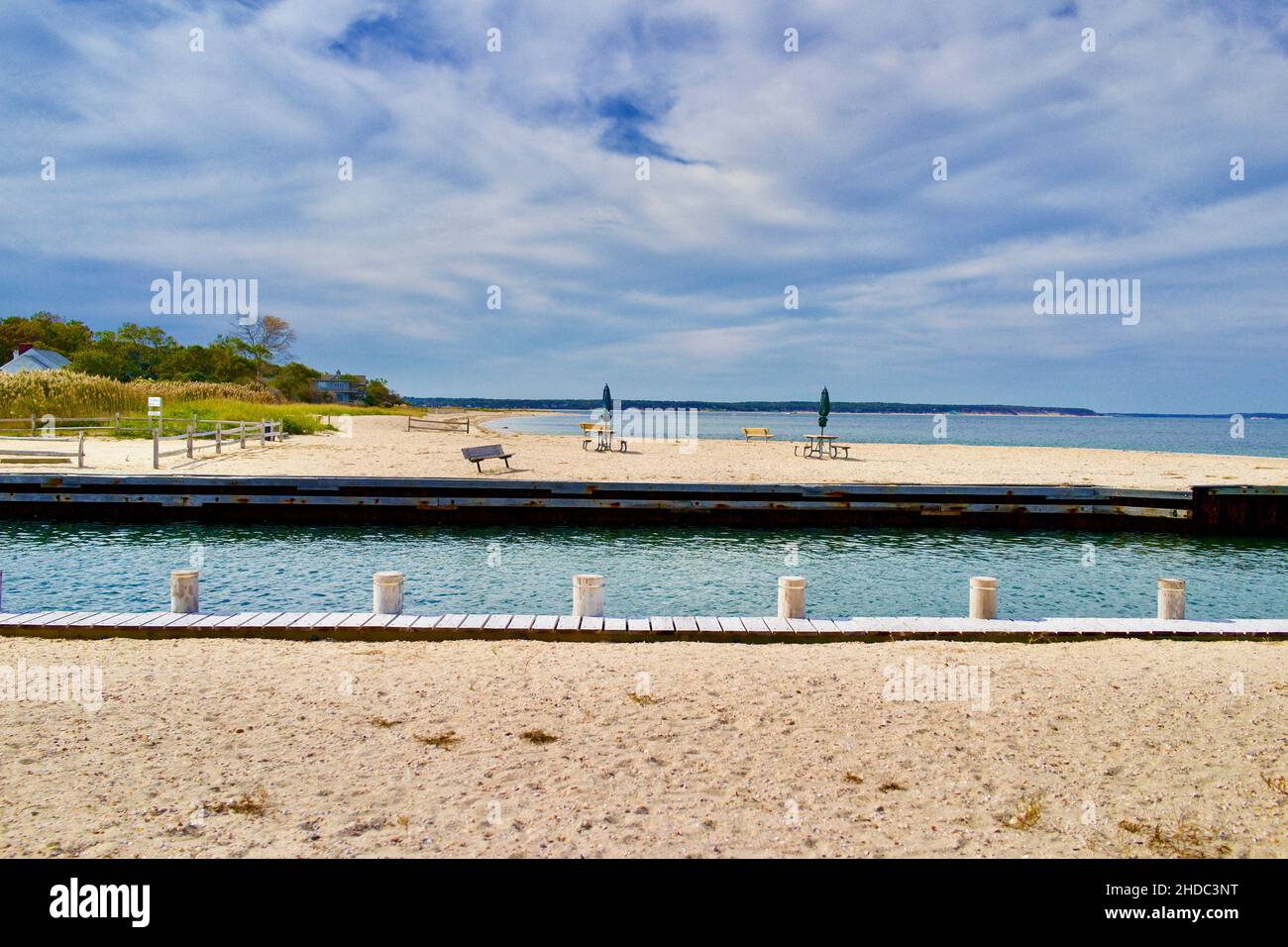 Boat channel and beach in East Hampton with benches.  Empty, no people in this bright summer day photograph. Stock Photo