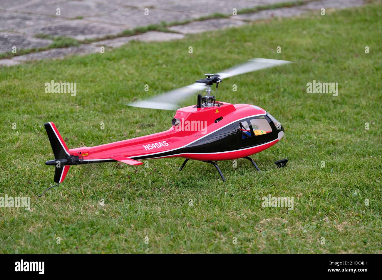 Neunhof, Germany  April 17, 2021: A radio controlled scale model of a AS350 Ecureuil helicopter is standing on a meadow in spring Stock Photo