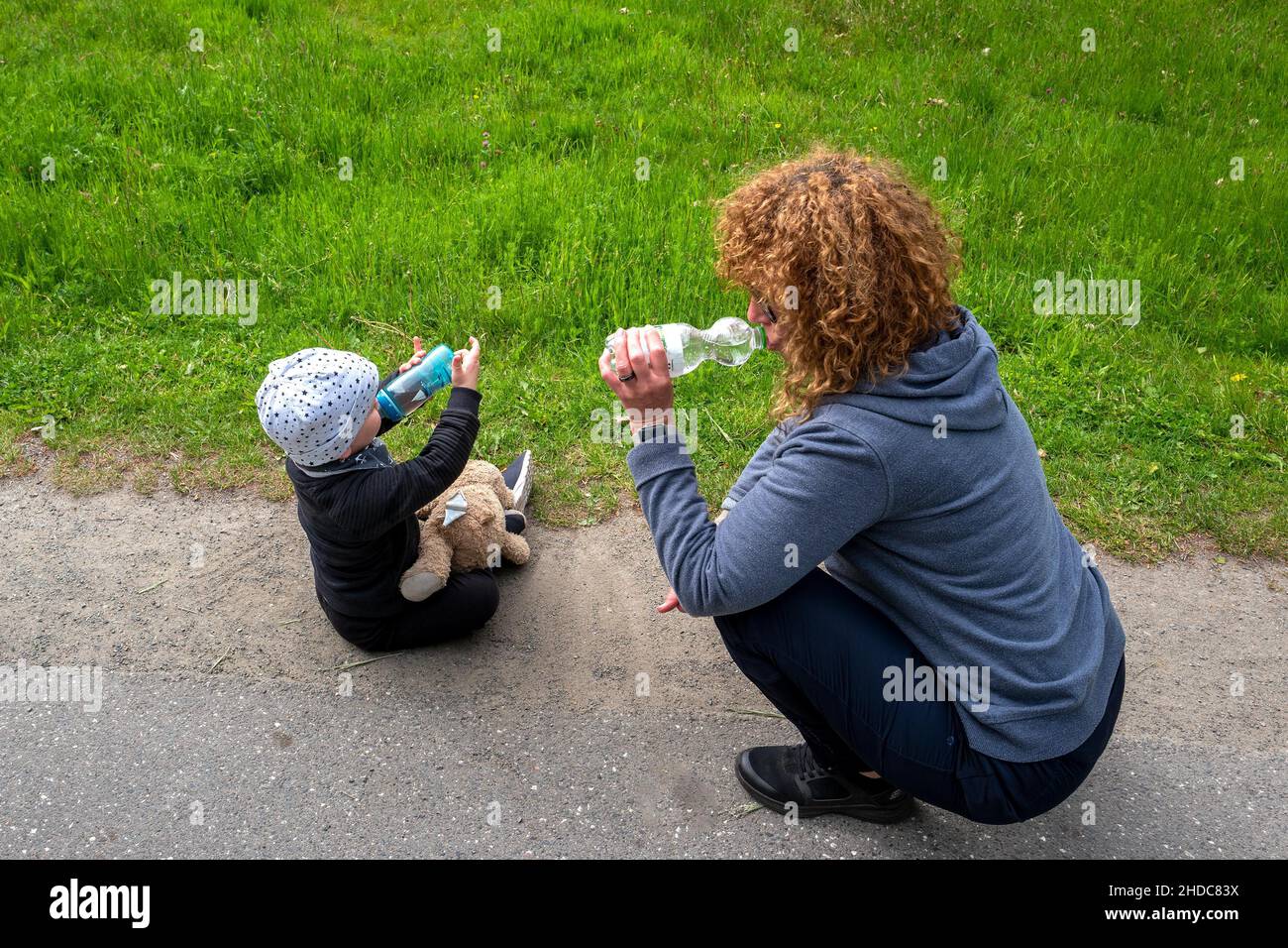 Woman and grandchild drinking from plastic bottle, Norderstedt, Schleswig Holstein, Germany, Europe Stock Photo