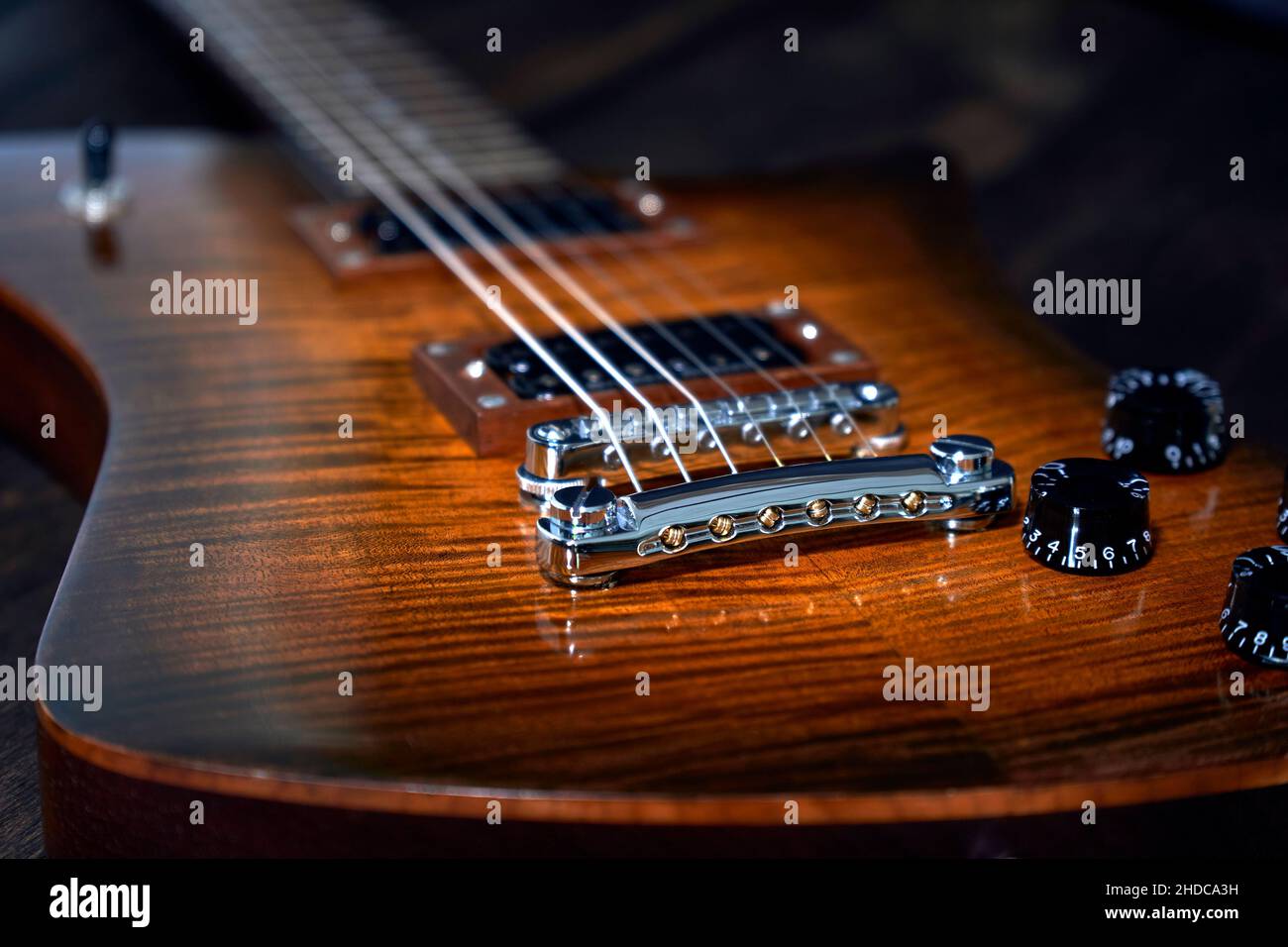 E-Gitarre Detailansicht mit schöner Holzmaserung auf dunklen Holz Hintergrund Stock Photo