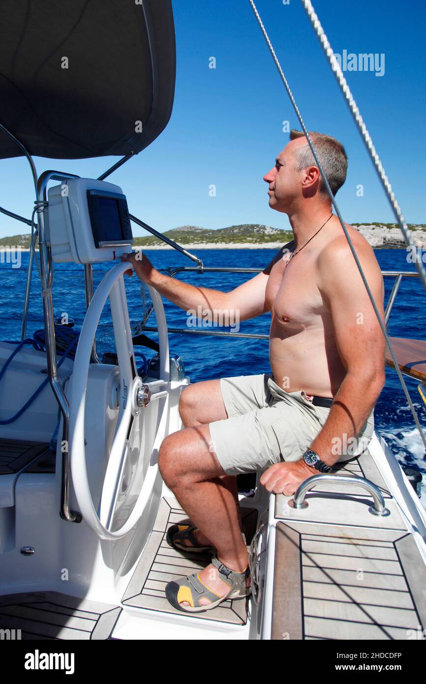 Segler am Steuer seiner Segelyacht in den Kornaten, Kornati Nationalpark, Kroatien, MODEL RELEASE VORHANDEN Stock Photo