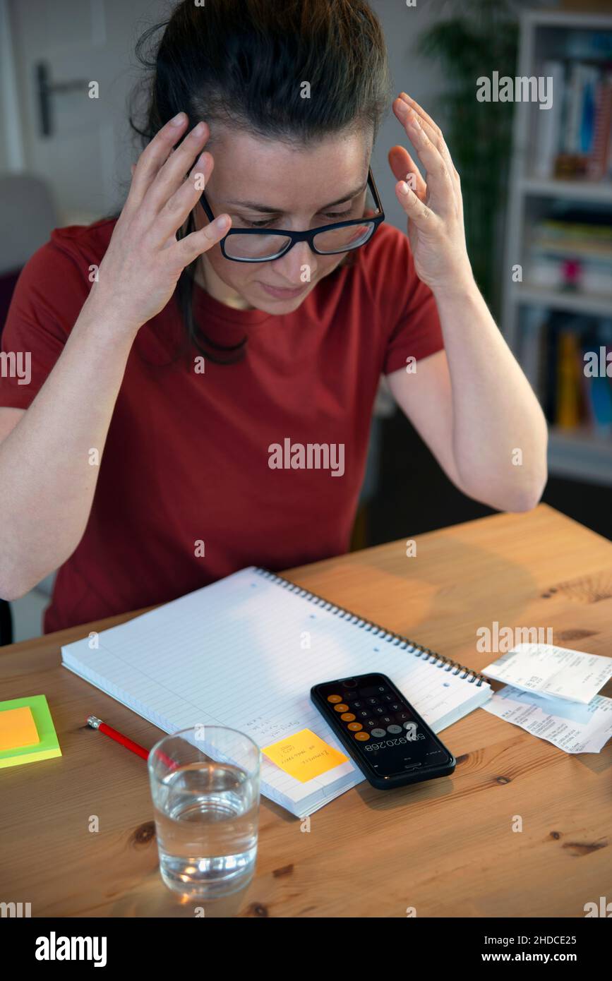 Frustrated small business owner doing expense accounting in a casual home office environment Stock Photo
