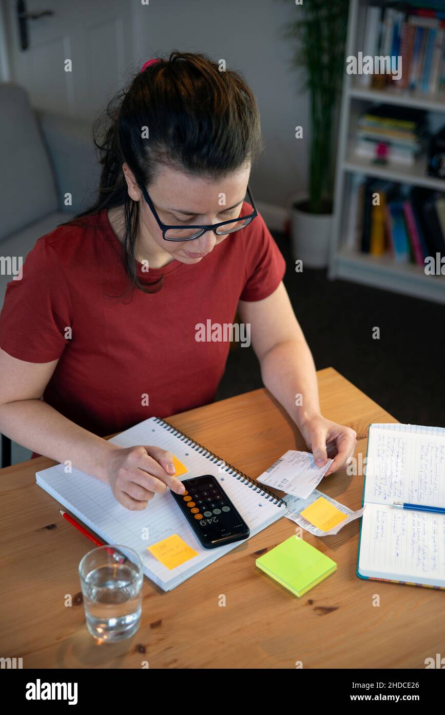 Small business owner doing paperwork in a casual home office environment Stock Photo