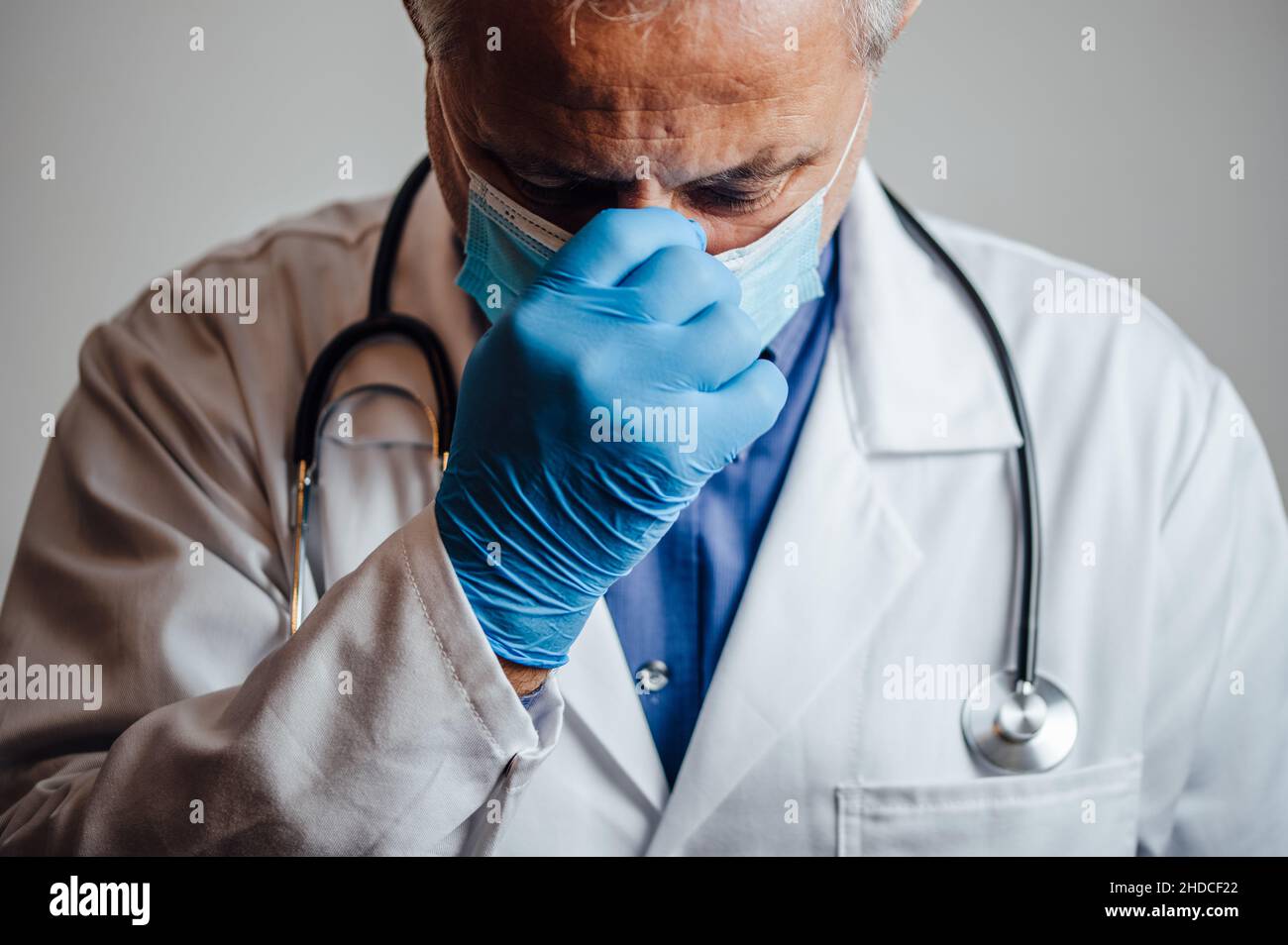Stressed out and overworked doctor holding his nose bridge Stock Photo