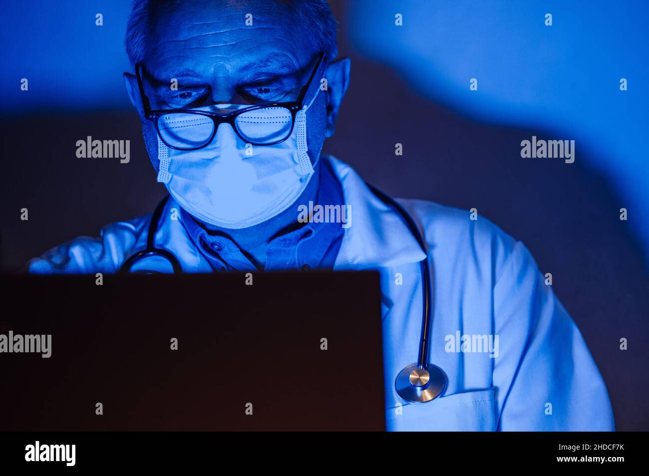 Doctor working on his computer late in the evening Stock Photo