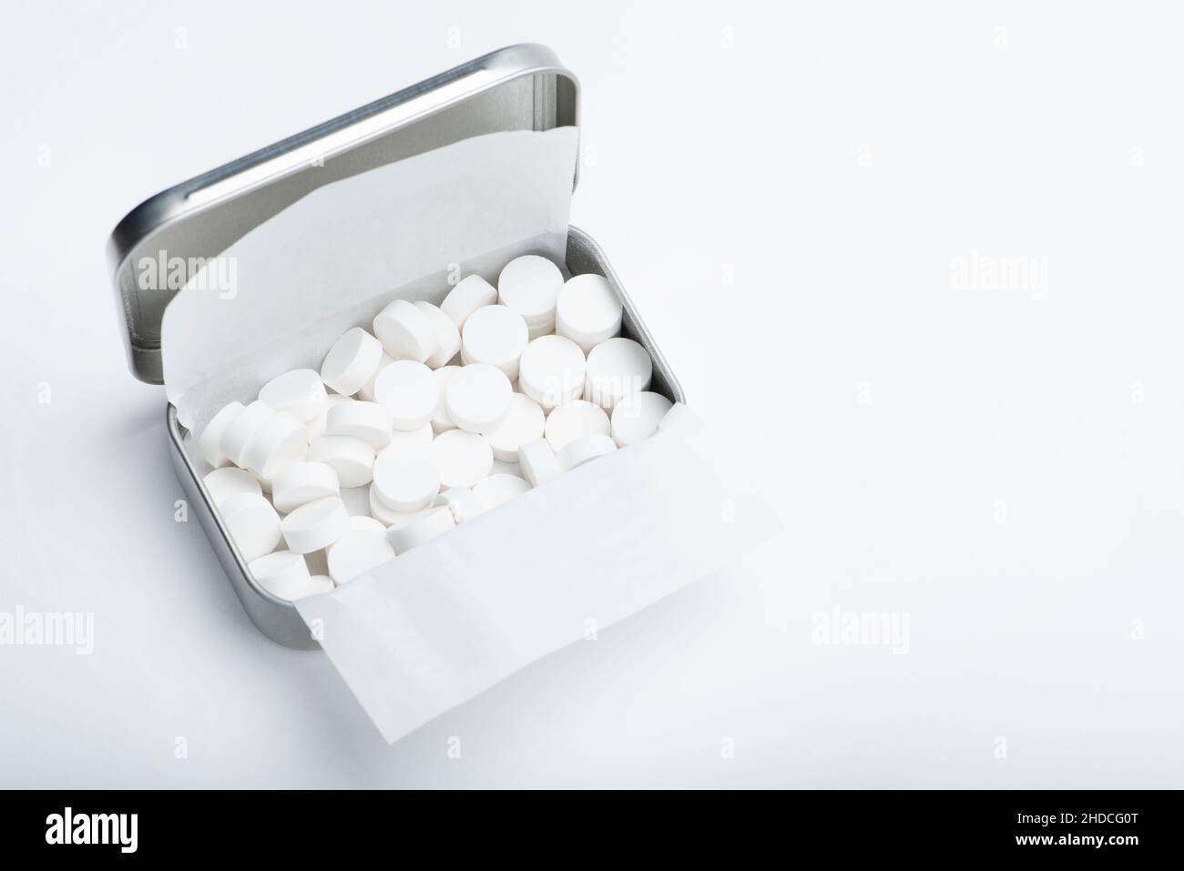 Mint candies on a white background. White mint candies in an open tin