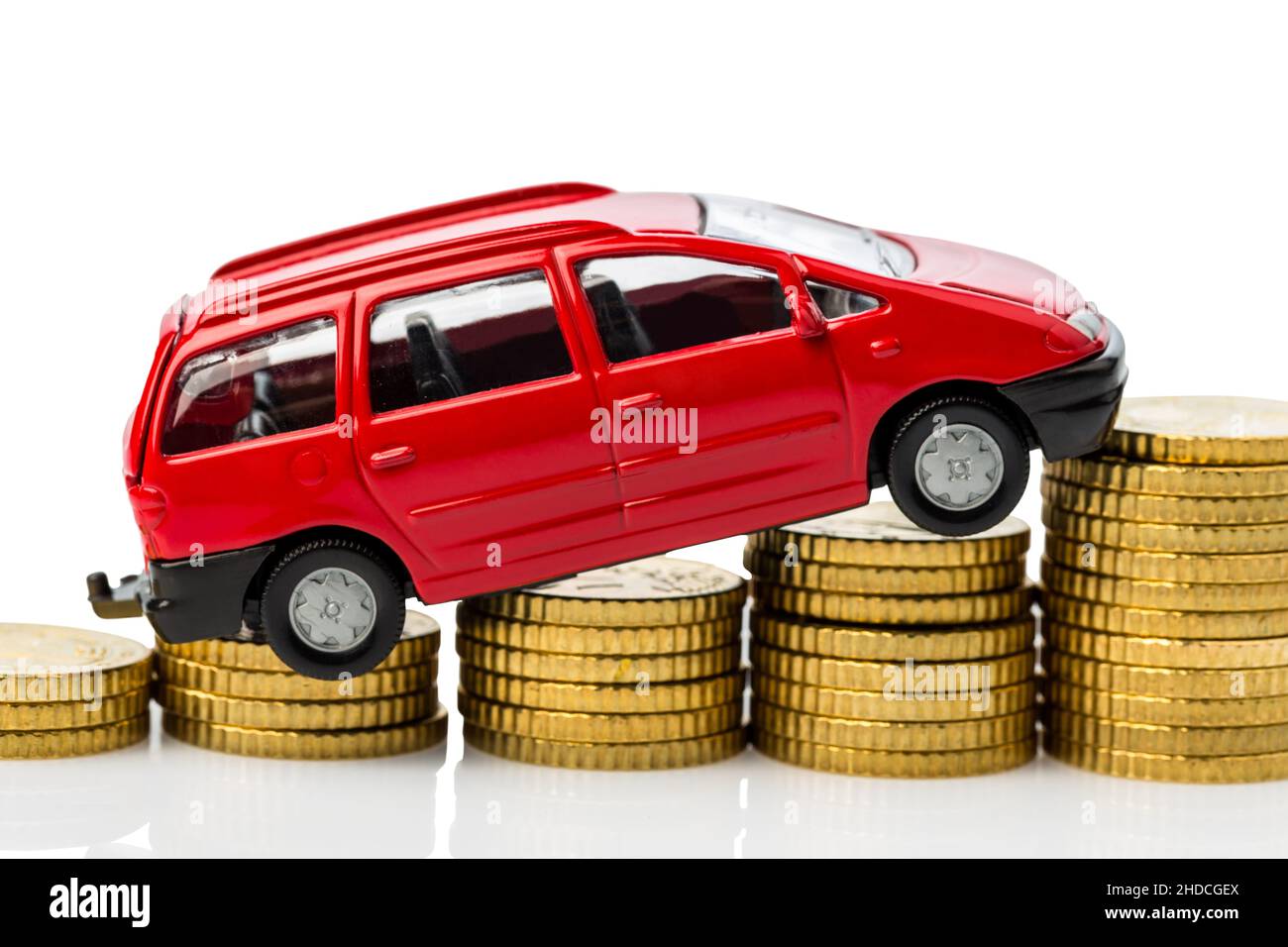 Ein Auto auf Muenzen. Symbolfoto fuer steigende Autokosten, Reperaturen und Benzin Stock Photo