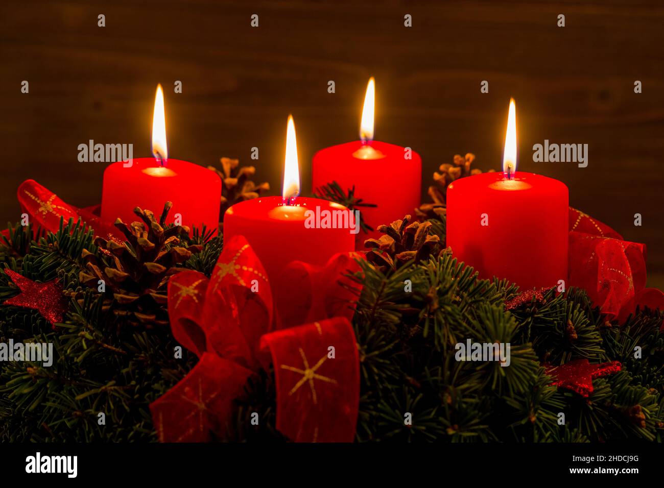 Ein Adventskranz zu Weihnachten sorgt für romatinsche Stimmung in der stillen Advent Zeit. 4 brennende Kerzen, 4. Advent, Stock Photo