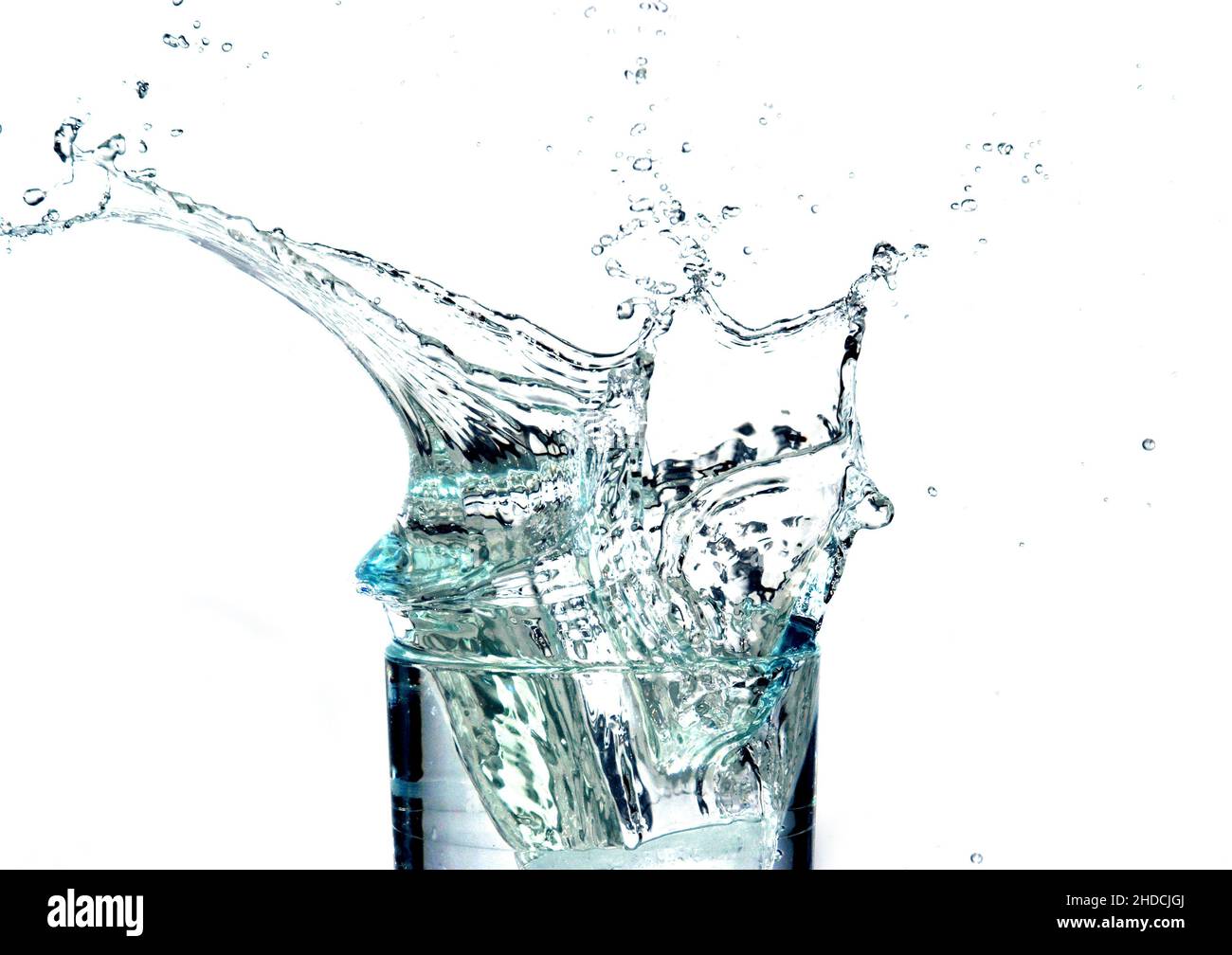 Eiswürfel fällt in ein Glas mit Flüssigkeit und schwappt über, Getränk, Limonade, Wasser, Wasserglas, Trinkwasser, Wasserspritzer, Stock Photo