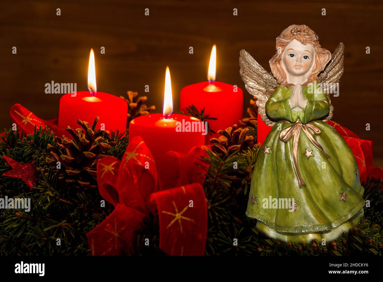 Ein Adventskranz zu Weihnachten sorgt für romatinsche Stimmung in der stillen Advent Zeit. 3 brennende Kerzen, 3. Advent, Engel, Weihnachtsengel, Stock Photo